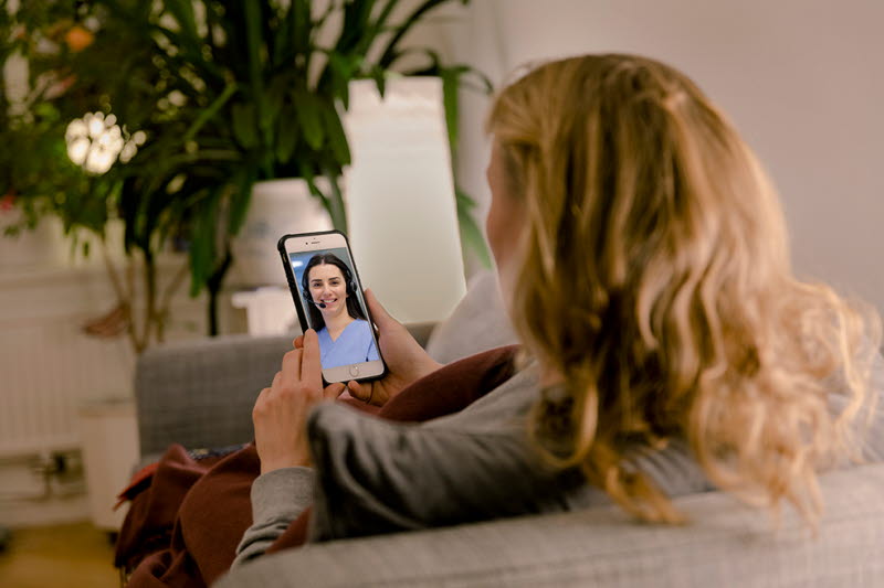 En person sedd bakifrån som tittar på Alltid öppet-appen i sin mobil
